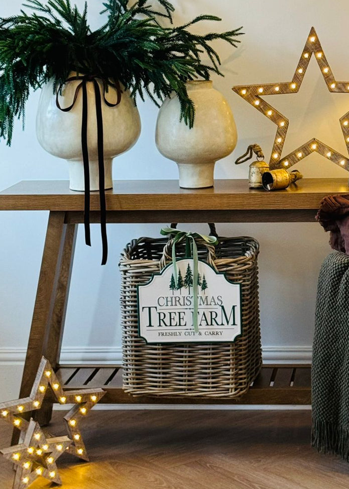 Decorative setup with a wooden table, plants, and fairy lights in a room.