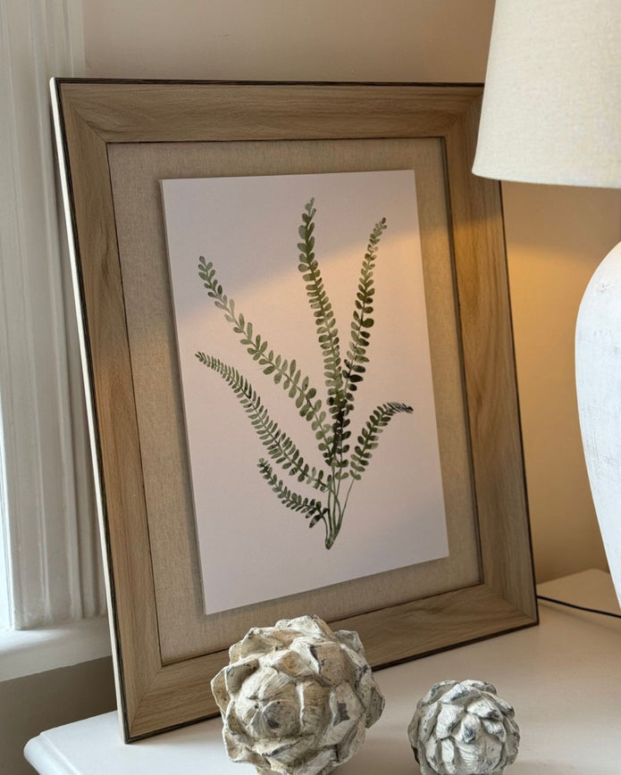 Wooden framed wall art print featuring vibrant green ferns, perfect for adding natural decor to any room.