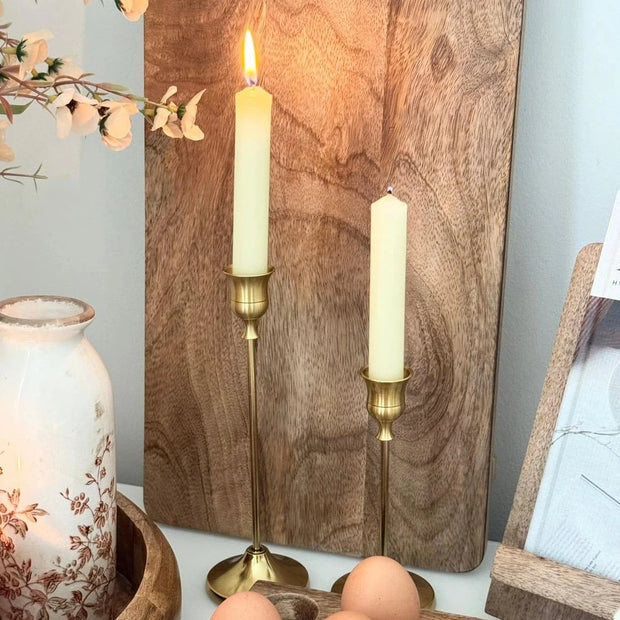 Antique Brass Effect Taper Candlestick, close-up of brass-effect candlesticks beside a wooden board