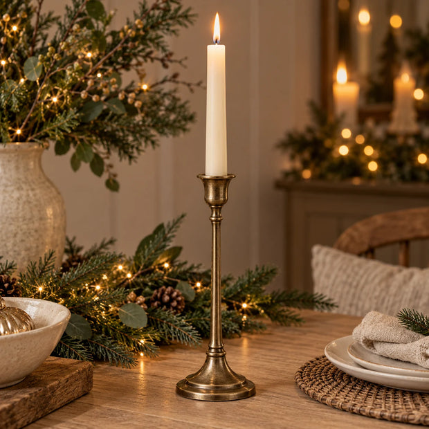 Antique brass effect taper candlestick for home decor, featuring a classic design, perfect for festive or elegant table settings.