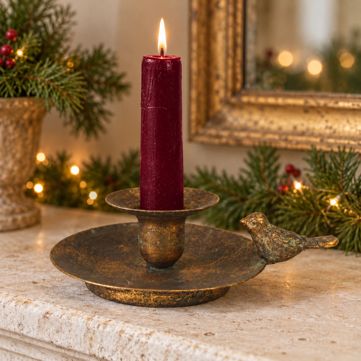 Antique bronze bird chamber stick candle holder by Originals International Ltd on a burgundy mantel