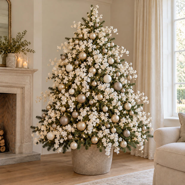 Multiple 85cm artificial white blossom stems styled on a Christmas tree with lights and neutral baubles; accessories excluded.