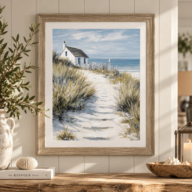 Artko Dune Cottage framed coastal wall art above a rustic wooden console in a neutral country home