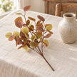 Christmas eucalyptus leaf sprig by Heaven Sends with green eucalyptus leaves and small white accents, styled for autumn decor.