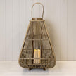 Bamboo lantern with an arched handle and LED candle on a pale shelf against white panelling
