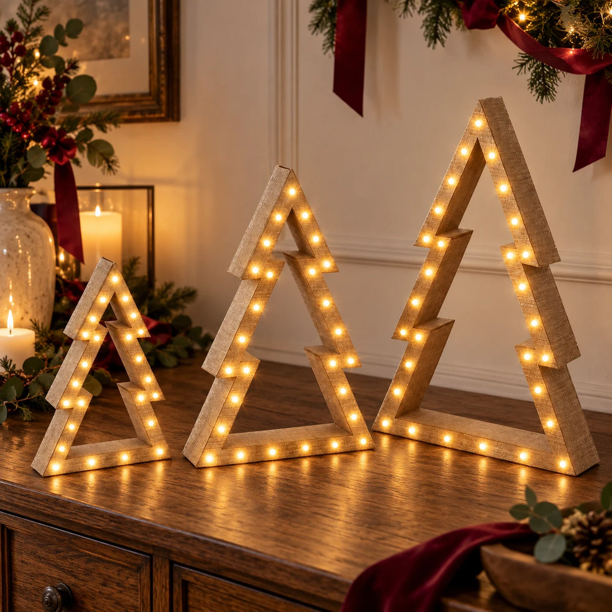 Beige wooden LED tree set glowing on a dark oak Christmas sideboard