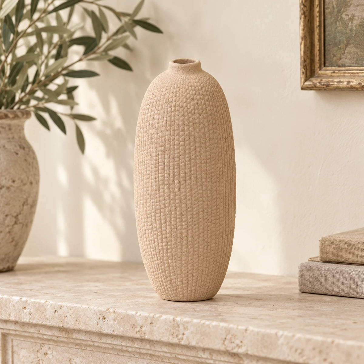 Slender beige textured vase displayed empty on a pale stone mantel