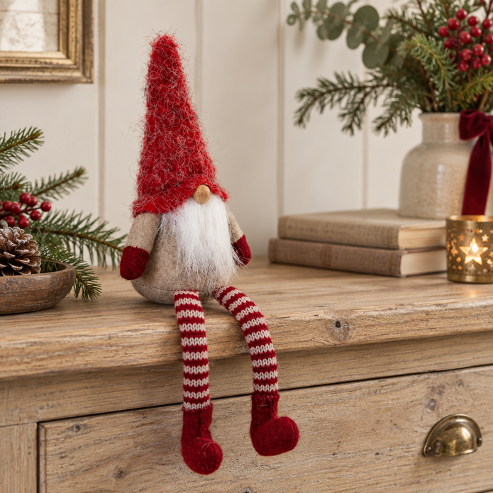 Sitting Red Woolly Christmas Gonk styled on an oak console