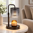 Black glass candle warmer lamp on a side table in a neutral reading room