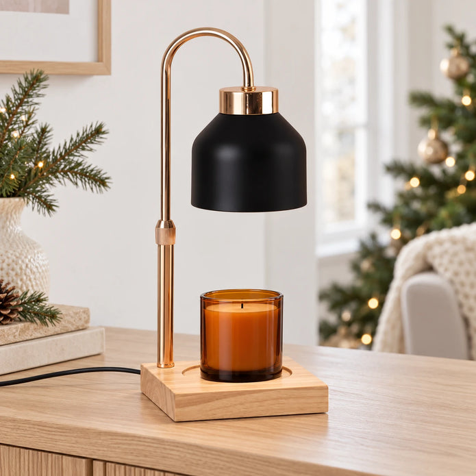Black enamel effect candle warmer with gold-tone arch and square wooden base, styled with an unlit candle