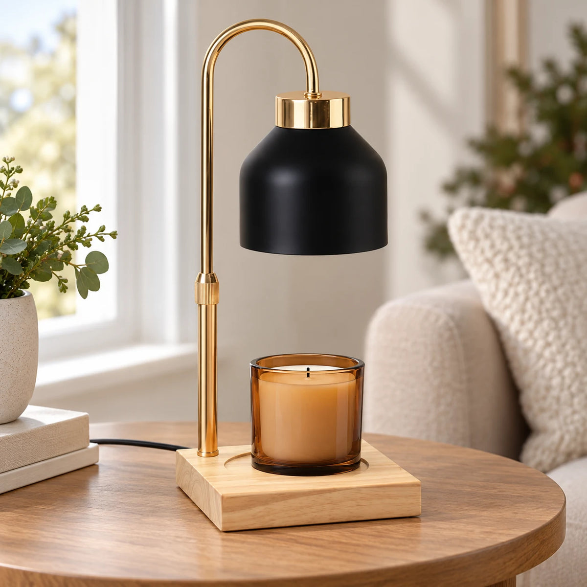 Black enamel effect candle warmer on a wooden side table beside a window with an unlit candle