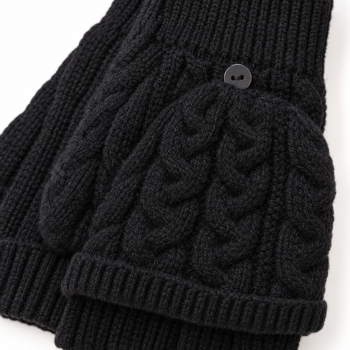 Close-up of black cable knit flip-top glove and fastening button