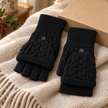Black cable knit flip-top gloves styled on an oatmeal throw with gift box