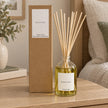 Black Oud Reed Diffuser with reeds inserted beside its matching kraft gift box.