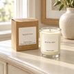 Heaven Scent Black Oud Small Candle with its kraft box on a console