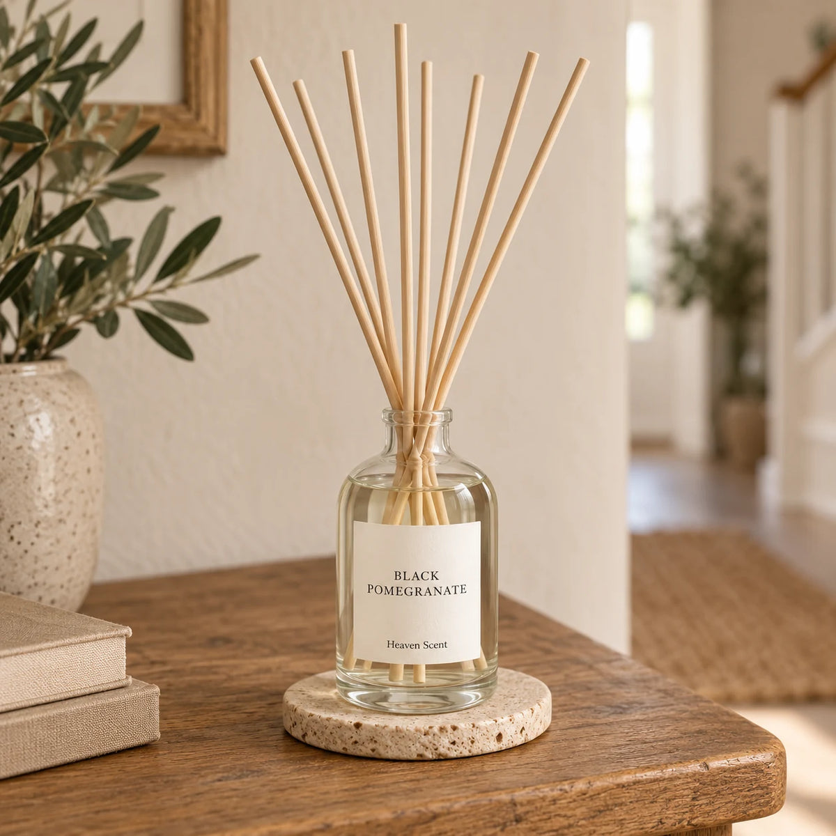 Black Pomegranate Reed Diffuser styled on an oak console with natural reeds inserted.