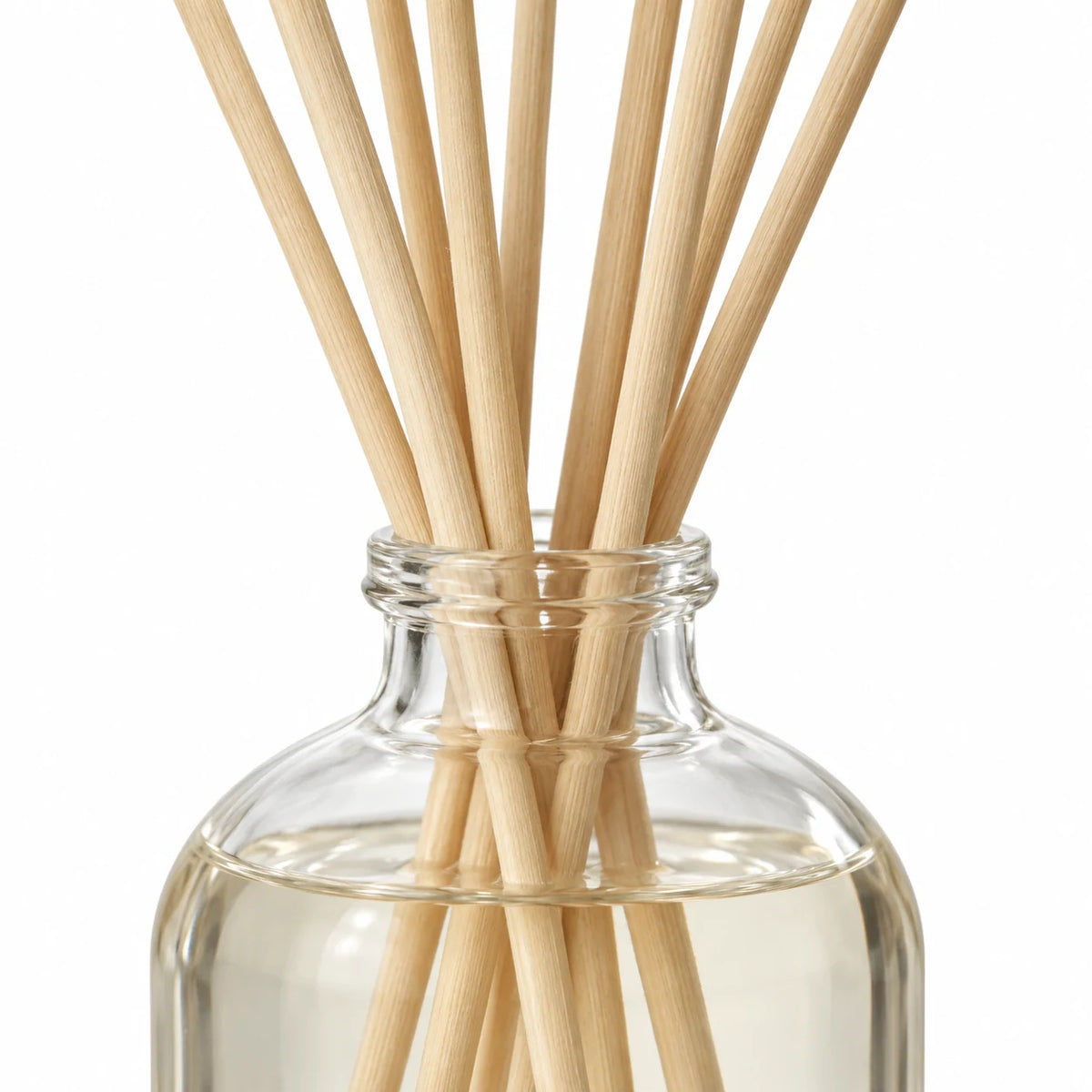 Black Pomegranate Reed Diffuser close-up of natural rattan reeds and the glass bottle neck.