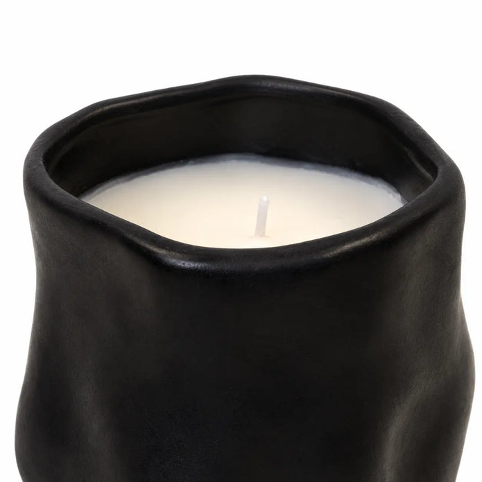 Close-up of the candle's wavy black rim, ivory wax and single unlit wick