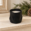 Black sculpted candle displayed unlit on a pale stone mantel