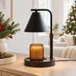 Black shade candle warmer lamp styled with an unlit amber jar candle on a Christmas console