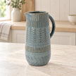 Large 32cm blue ceramic jug with mottled glaze and textured bands, kitchen view.