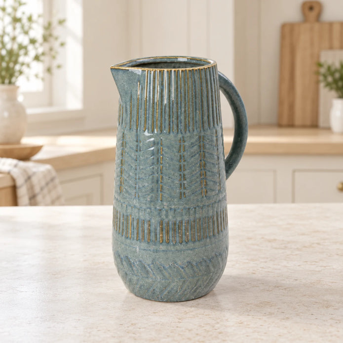 Medium 27cm blue ceramic jug with mottled glaze and textured bands, kitchen view.
