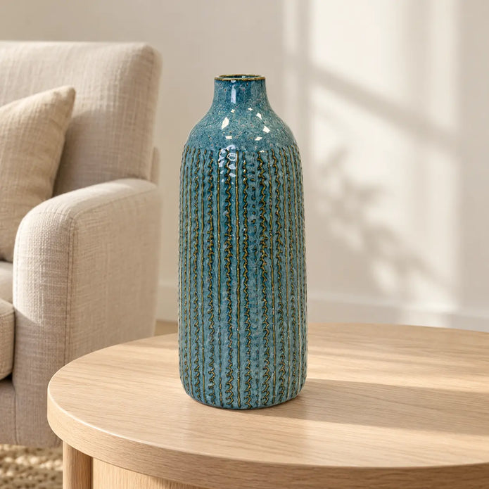 Large blue ceramic vase on an oak side table in a neutral living room.