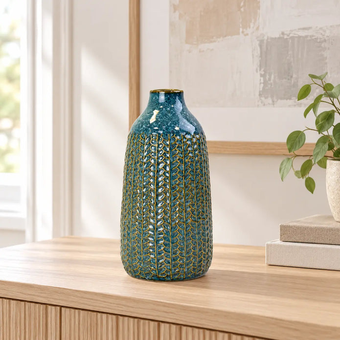 Medium blue ceramic vase on an oak console in a bright neutral interior.
