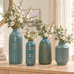 Four blue ceramic vase designs shown together for size comparison: 38cm, 26cm, 29cm and 25cm, styled with white flowers and eucalyptus; sold separately.