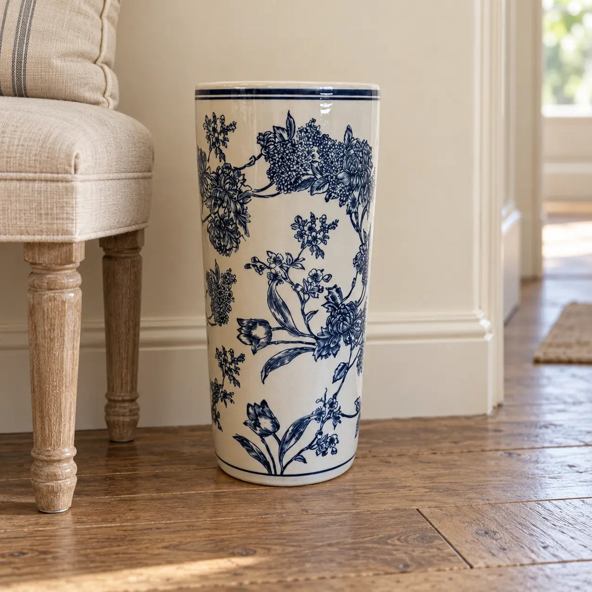 Magnolia print umbrella stand beside an oatmeal bench on an oak hallway floor