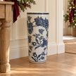 Blue and white magnolia umbrella stand beside an oak console with Christmas greenery