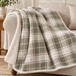 Riva Home Braemar check sherpa fleece throw in green and natural draped over a sofa arm