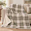 Riva Home Braemar check sherpa fleece throw in green and natural draped over a sofa