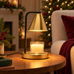 Brass-effect candle warmer lamp on an oak side table in a cosy festive living room