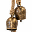 Close-up of mottled brass-toned cowbells and knotted natural-coloured rope