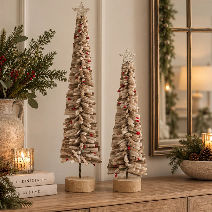 Tall and short neutral brown layered felt Christmas trees with tiny red berry accents in festive living room