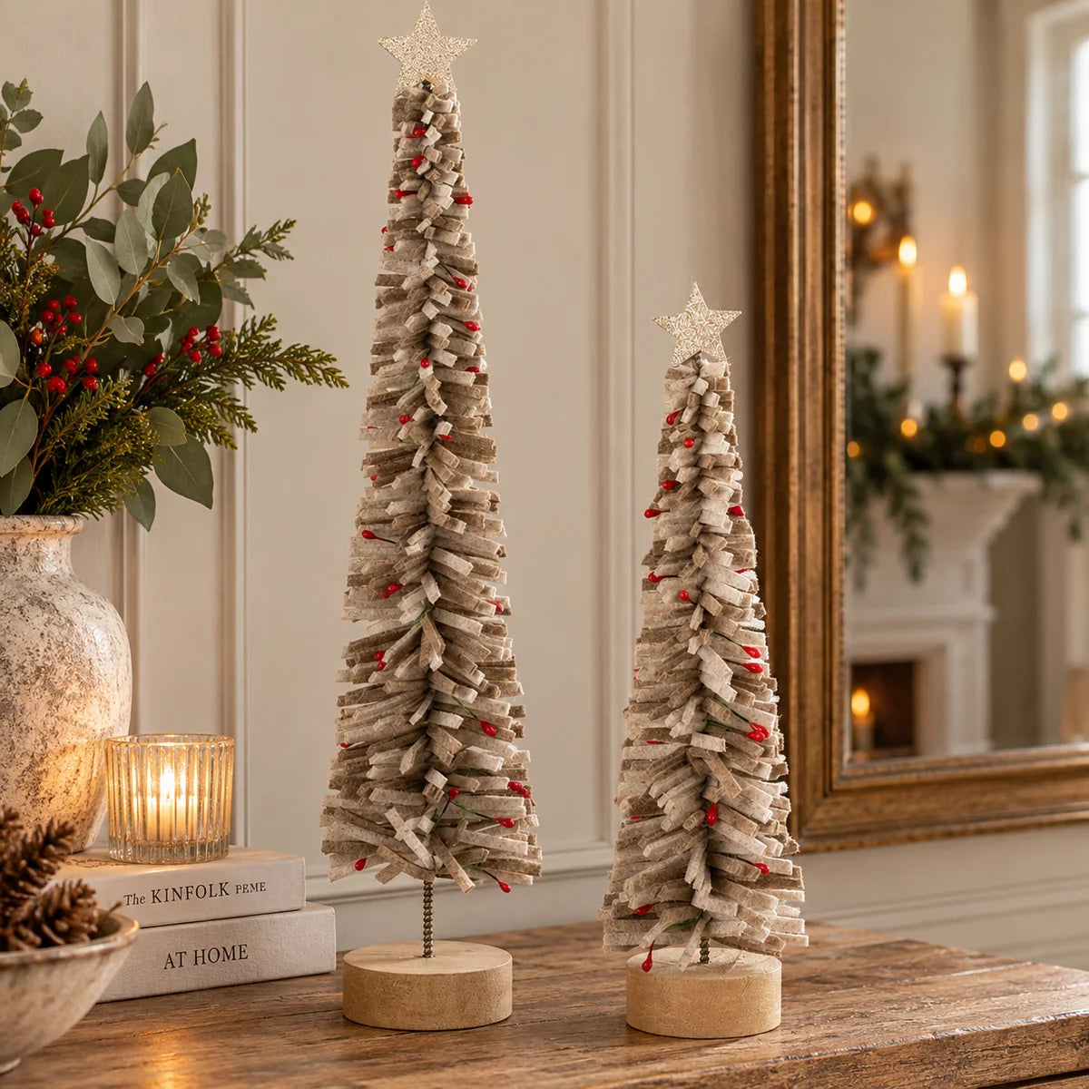Two individually sold brown felt Christmas trees with wooden bases and glitter stars displayed by mirror