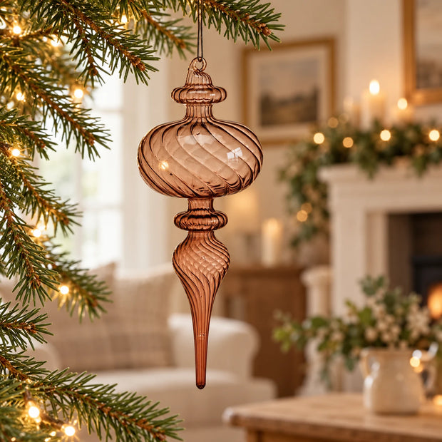Brown Glass Teardrop Christmas Bauble — longer finial hanging on fir branch with warm cream country interior blurred behind