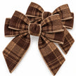 Close-up of two brown checked tweed bows showing stitched edging and woven texture