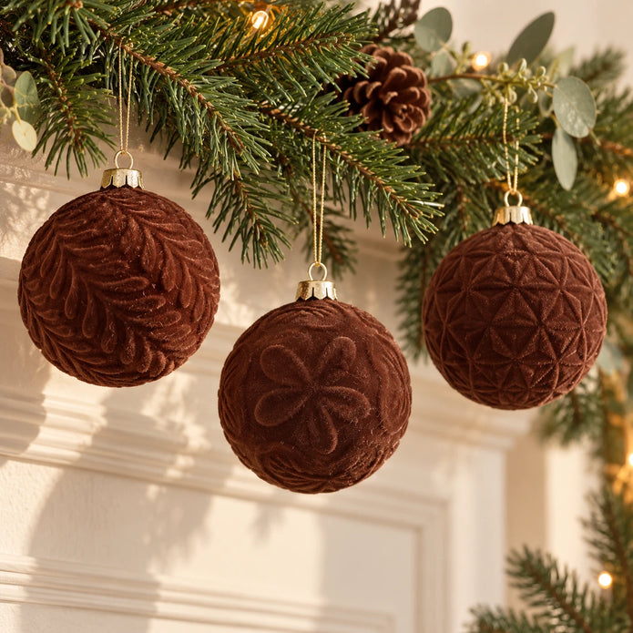 Brown velvet Christmas bauble from Starlight Express hanging on a festive garland, showcasing its soft texture and elegant design.