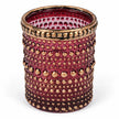 Empty burgundy dotted glass tealight holder with distressed gold rim on white, close detail view.