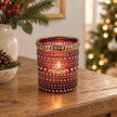 Burgundy dotted glass tealight holder with distressed gold rim, styled with a candle on an oak console at Christmas.