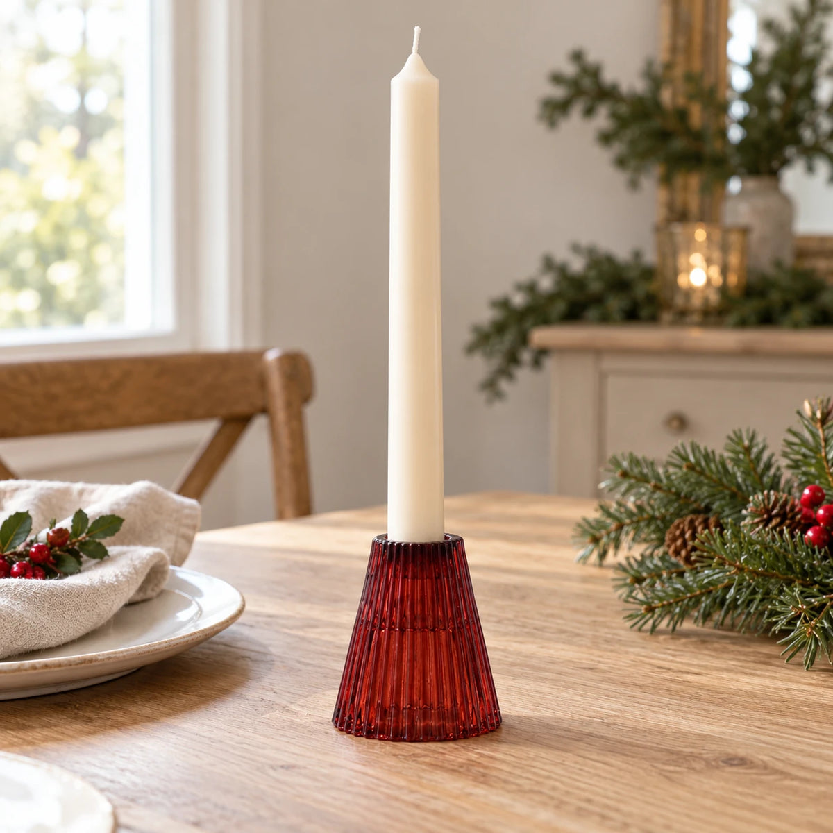 Burgundy ribbed glass candle holder with ivory dinner candle on a Christmas dining table