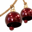 Close-up of glossy burgundy metal bells with ball clappers and gold-coloured fittings