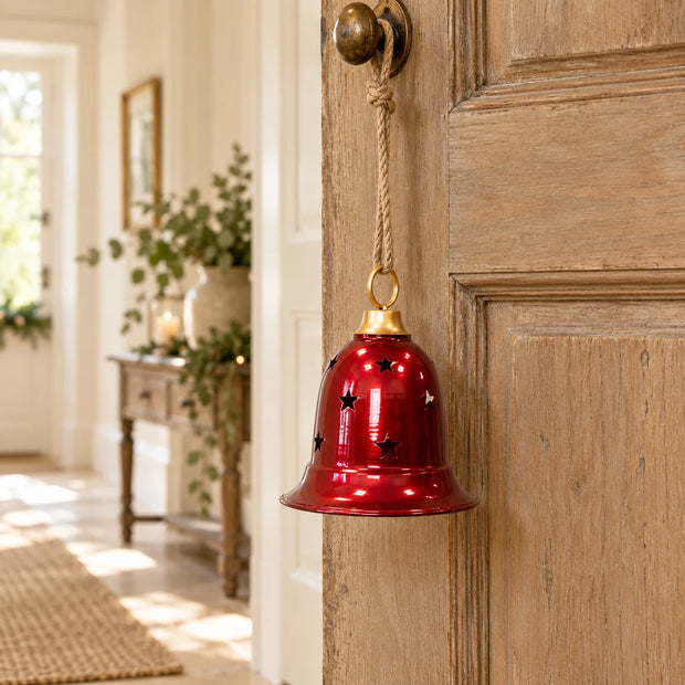 Burgundy metal cowbell hanging on a wooden door, Christmas decoration by Satchville