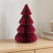 Burgundy folded paper Christmas tree on a pale oak console beside books.