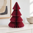 Claret red paper Christmas tree displayed on a white sideboard in daylight.
