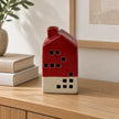 Burgundy red and cream ceramic LED house, unlit on an oak console.