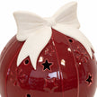 Close-up of the ivory ceramic bow and star cut-outs on a burgundy red bauble