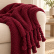 Burgundy Sherpa tasselled blanket throw from Riva Home, showcasing soft plush fabric and decorative tassels.